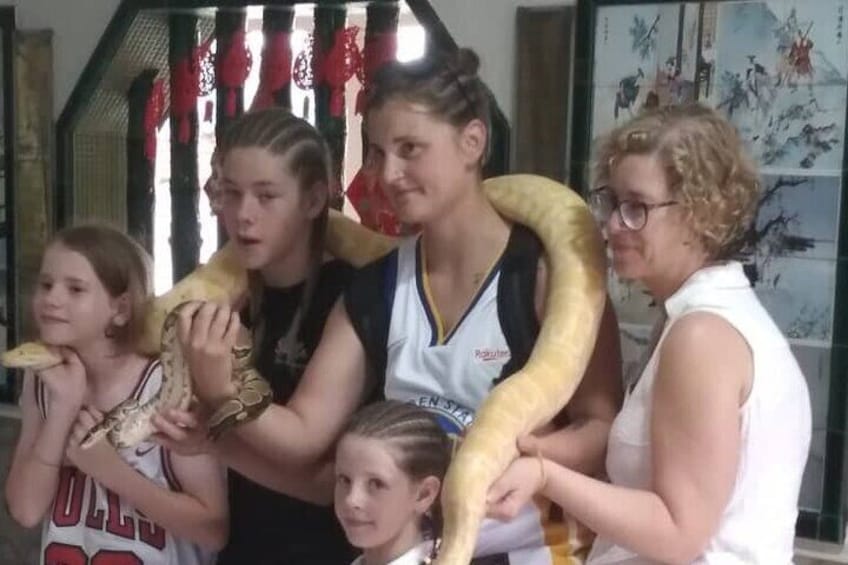 A group of people with a large snake. 4