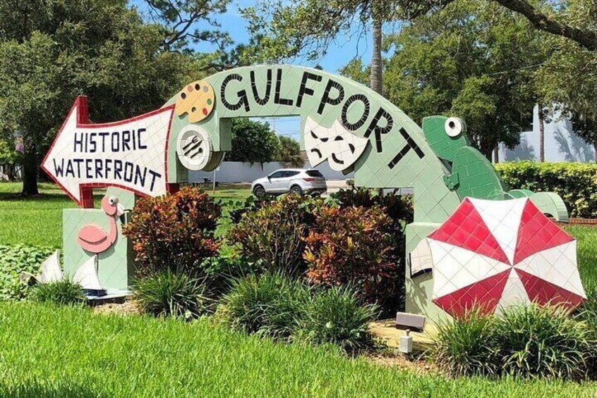 A sign for Gulfport's historic waterfront with a flamingo, a cat, and a turtle. 1