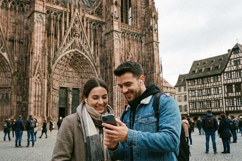Une cathédrale à l’architecture gothique, une personne tenant un téléphone intelligent et une autre personne portant une veste en jean. 3