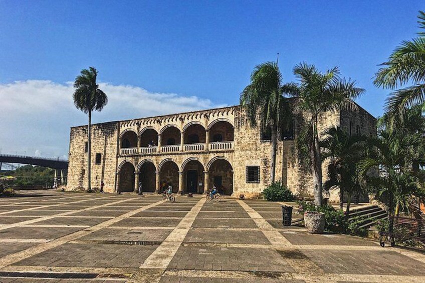 A historic building with arches and palm trees. 4