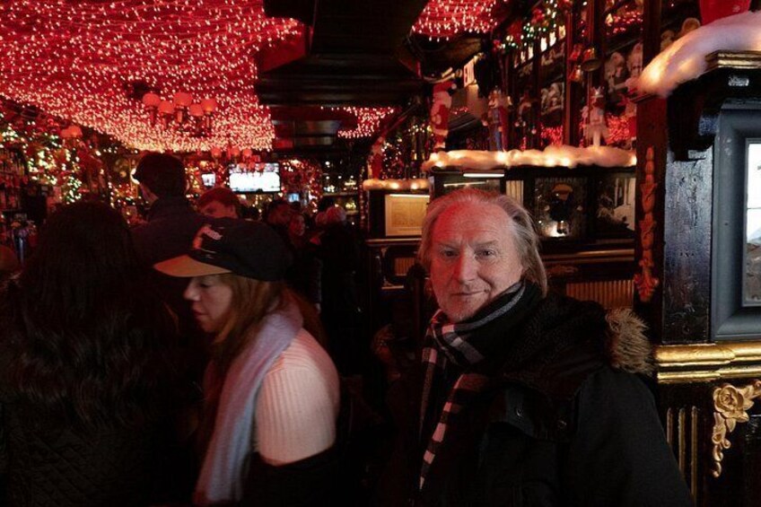 A crowded indoor space with red lighting and a person in a black coat. 4