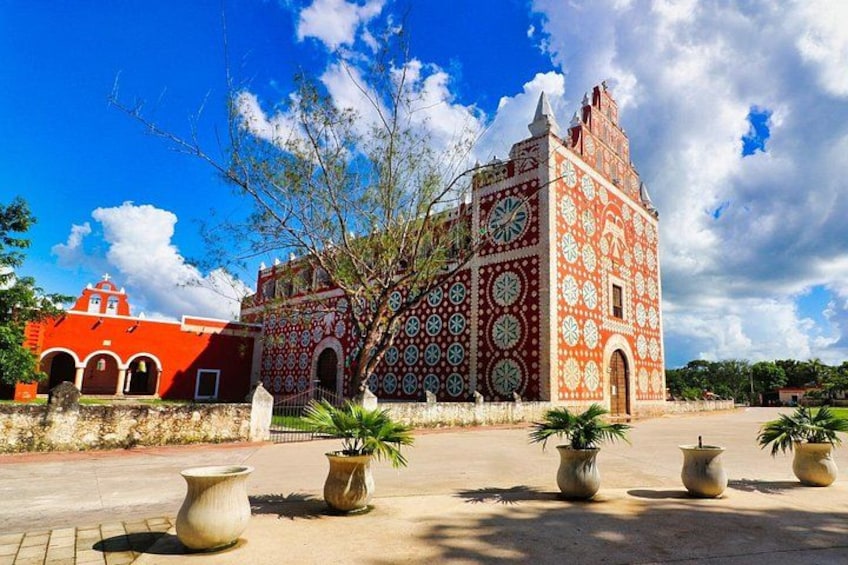 A building with intricate tile patterns, a clock, and a red tower. 3