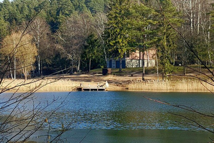 A lake with a dock, surrounded by trees and a building in the background. 4