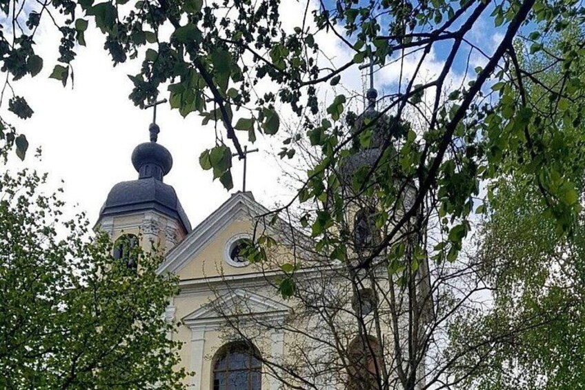 A church with a prominent dome and bell tower, surrounded by trees. 5