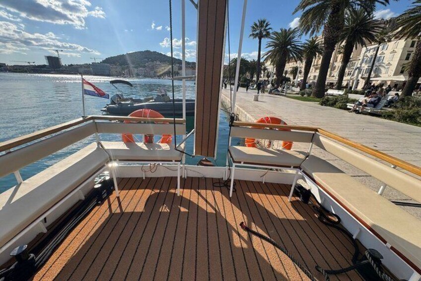 Une terrasse en bois équipée de bouées de sauvetage, un ciel dégagé et une marina remplie de bateaux. 5