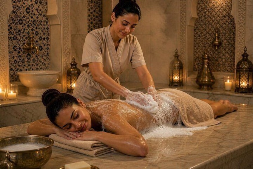 Eine Person erhält eine Massage in einem Spa-Bereich mit Wandmuster und Kerzen. 4
