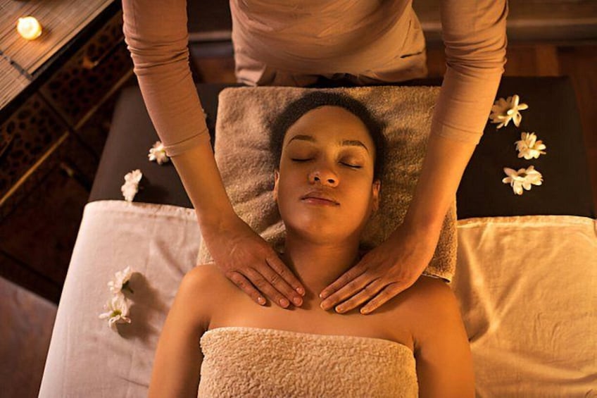 Eine Person bekommt eine Massage, Blumen liegen auf einem Handtuch. 5