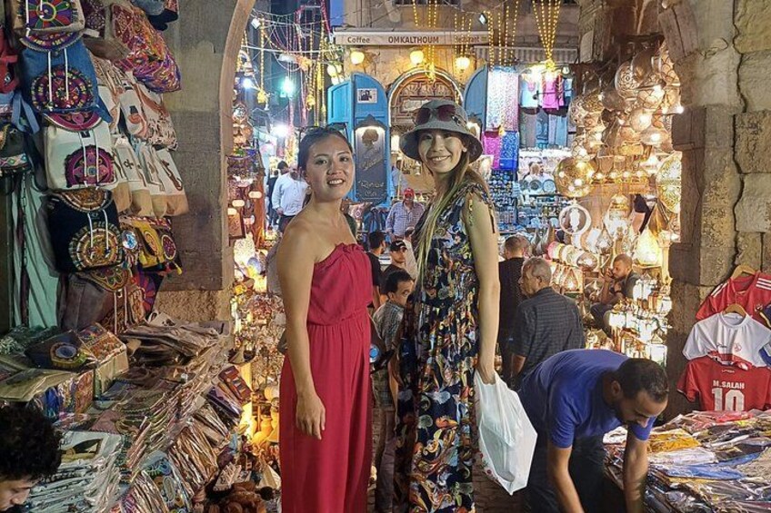 Un mercado concurrido con puestos que venden joyería y textiles. 4