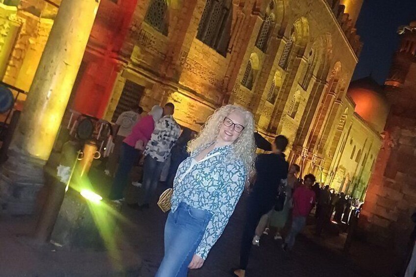 Une personne se tient devant un bâtiment historique, orné de colonnes et d’arcades. 3