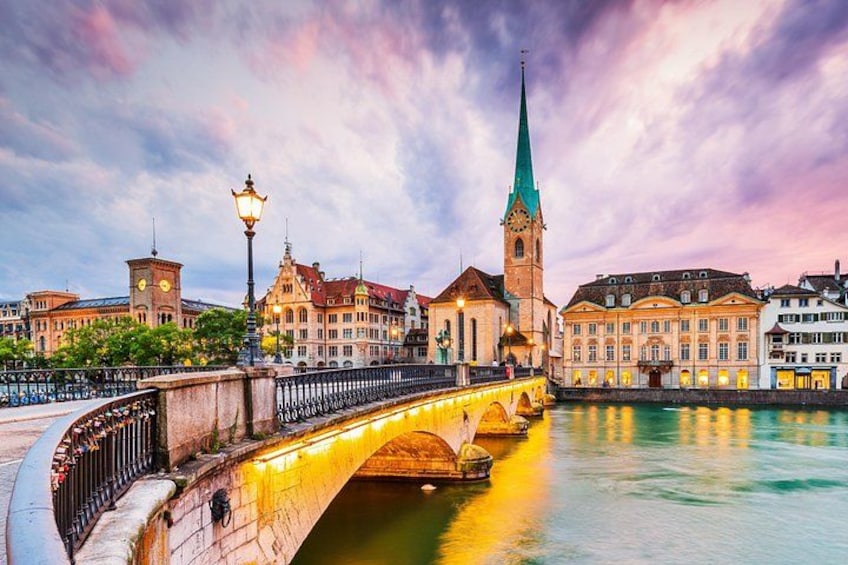 A bridge over a river with historic buildings and a church tower. 3