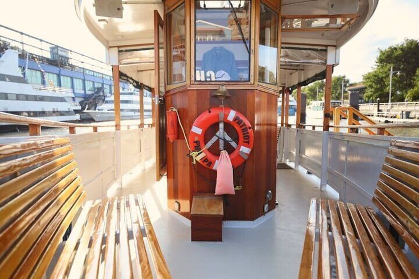 Een houten dek met een reddingsboei en een reddingskrans op een boot. 5