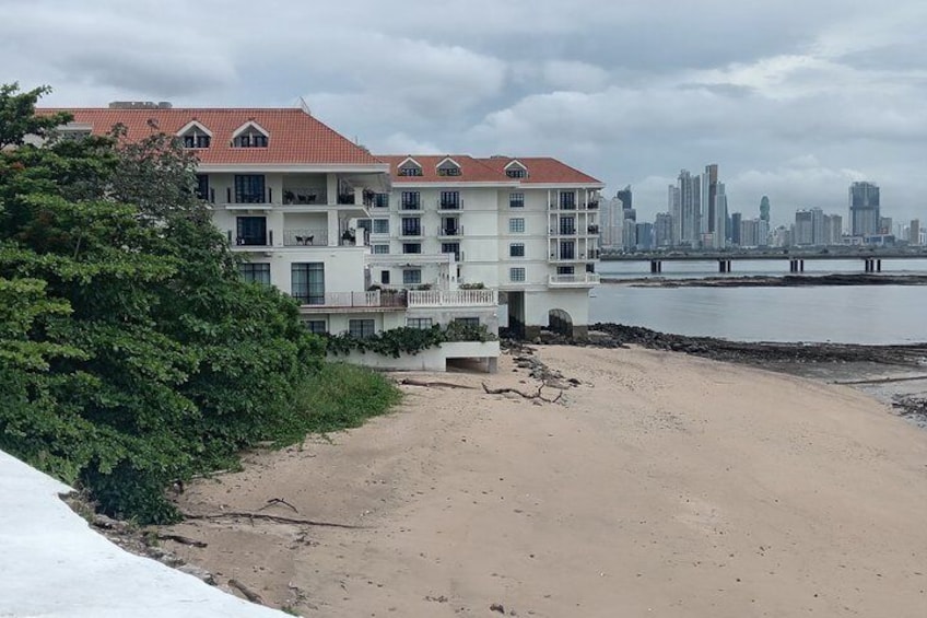 Een strand met een gebouw en een stadsachtergrond. 3