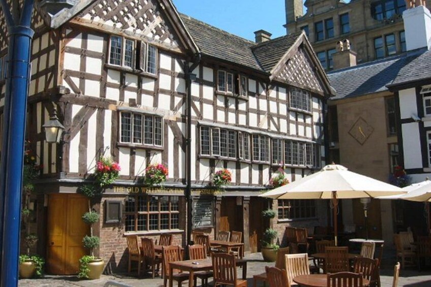 A traditional half-timbered building with outdoor seating and flower arrangements. 3