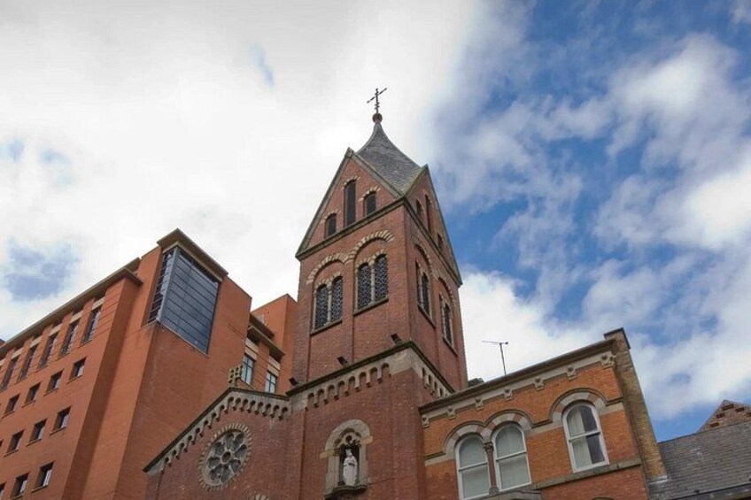 A red brick church with a tall tower and a clock. 5