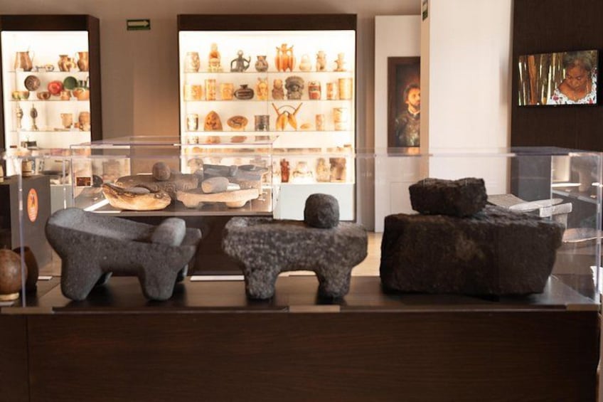 Una exhibición de museo con esculturas de piedra y cerámica. 4