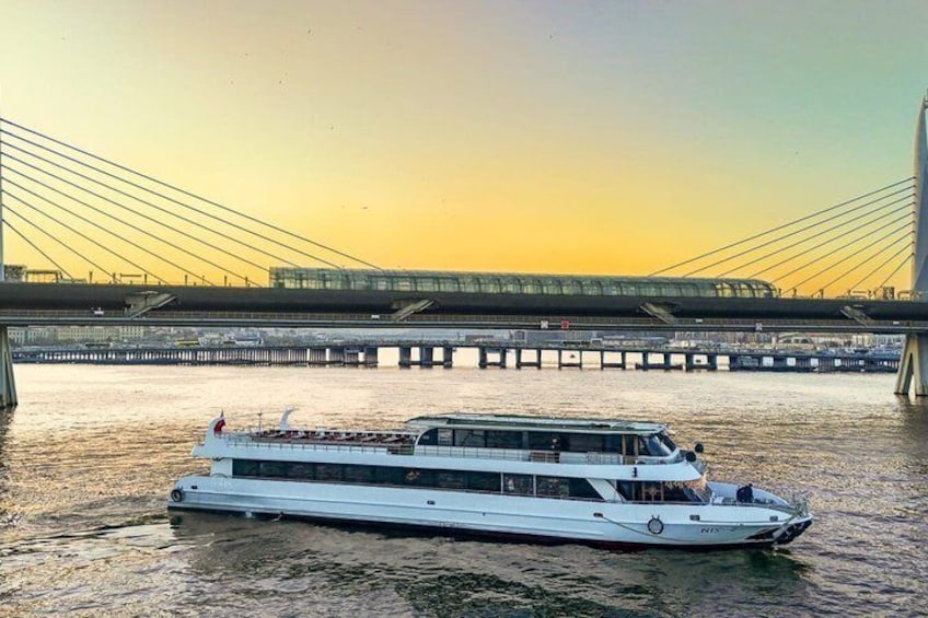 A river cruise boat on a river with a bridge in the background. 1