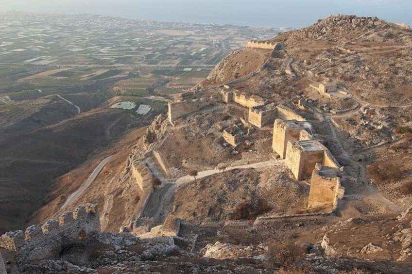 Una antigua estructura fortificada con ruinas en una colina que domina un valle. 3