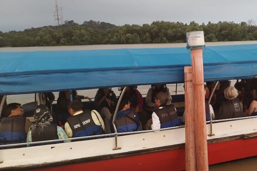 Un'imbarcazione con persone che indossano giubbotti di salvataggio e un telo blu che copre la parte anteriore. 3