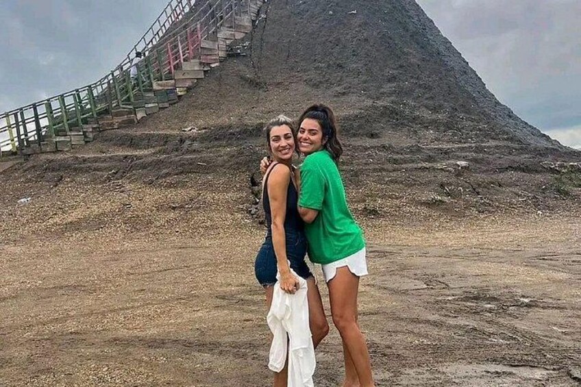 Dos personas de pie frente a una colina extensa con una escalera que asciende. 4