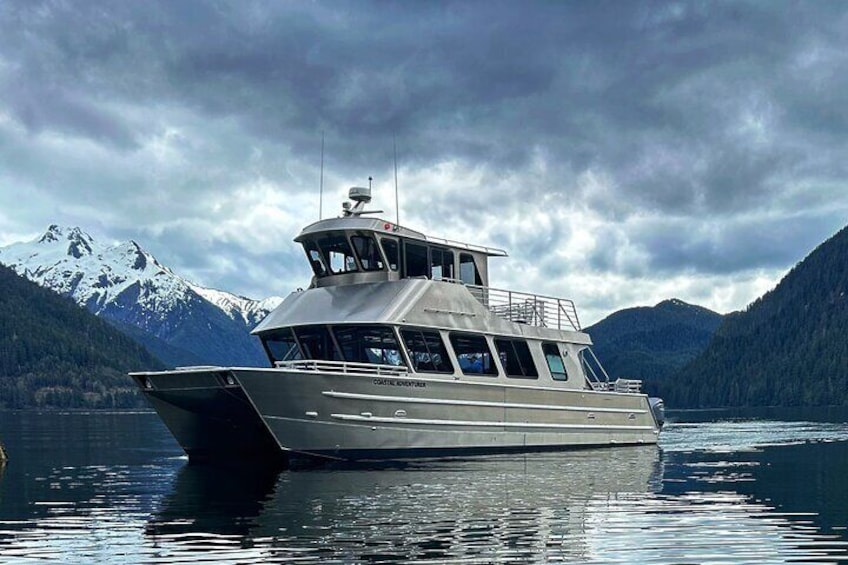 Een boot op een kalm meer met besneeuwde bergen op de achtergrond. 1