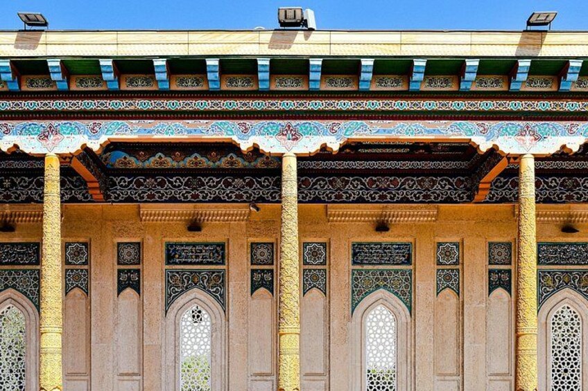 A building with intricate tile work, arched doorways, and columns. 4