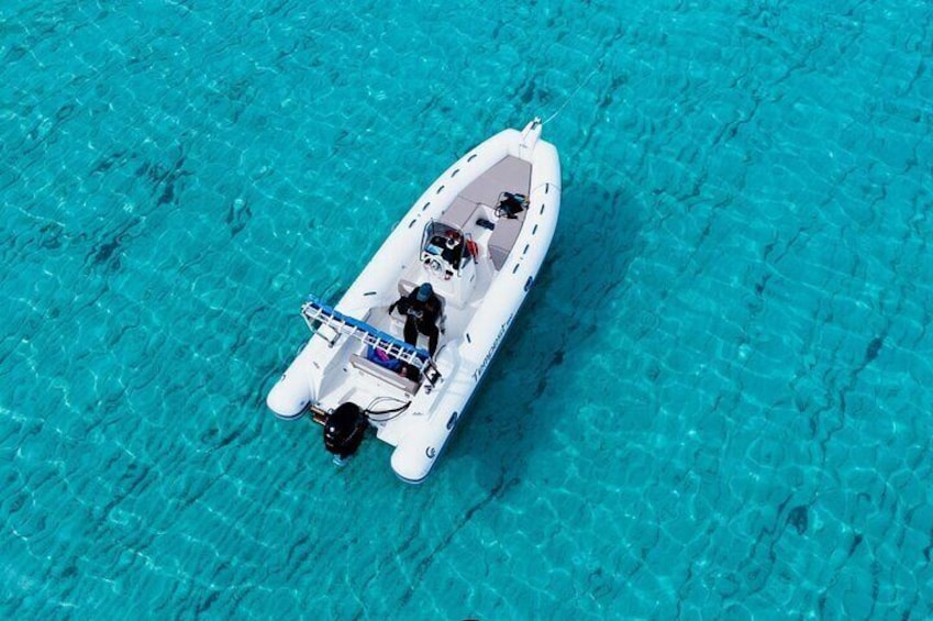Een witte motorboot op helder turquoise water. 1