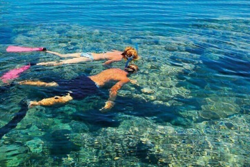 Two people snorkeling in clear blue water. 3