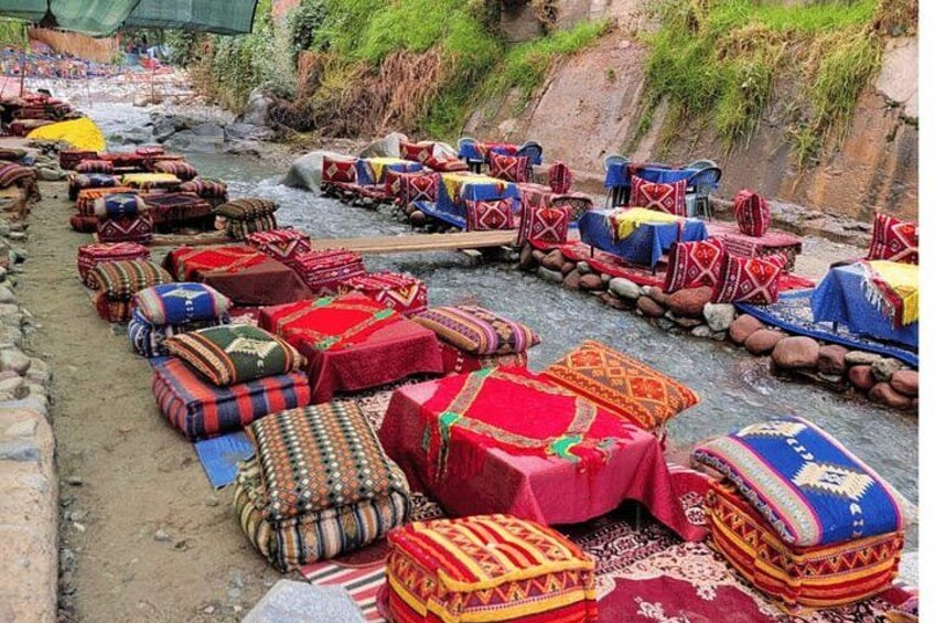 Colorful textiles and rugs laid out on a riverbank. 1