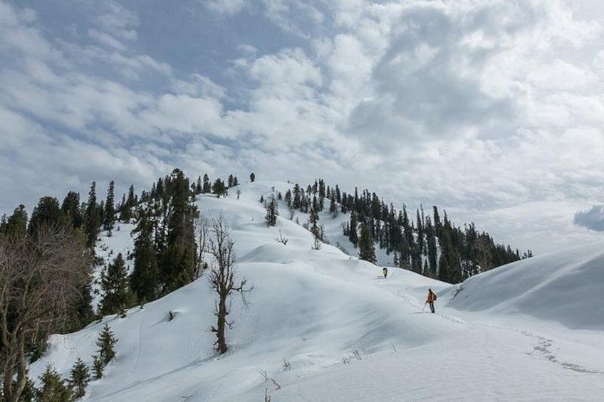 A snowy mountain landscape with skiers and a clear sky. 4