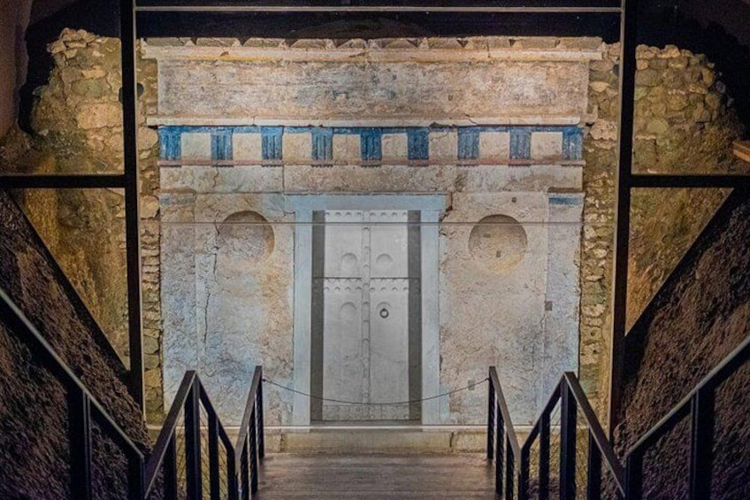 Un edificio de piedra con una puerta central, flanqueada por dos nichos arqueados, y una escalera que conduce a ella. 1