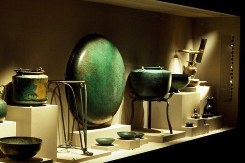 A display of green ceramic bowls and pots on stands. 3