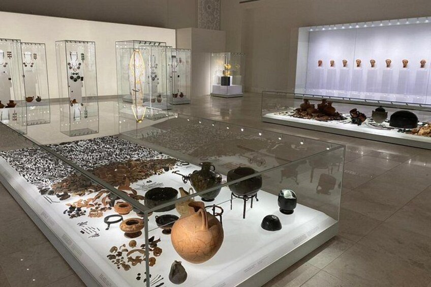 Una exhibición en museo en interiores con vitrinas de vidrio que contienen varios artefactos. 5