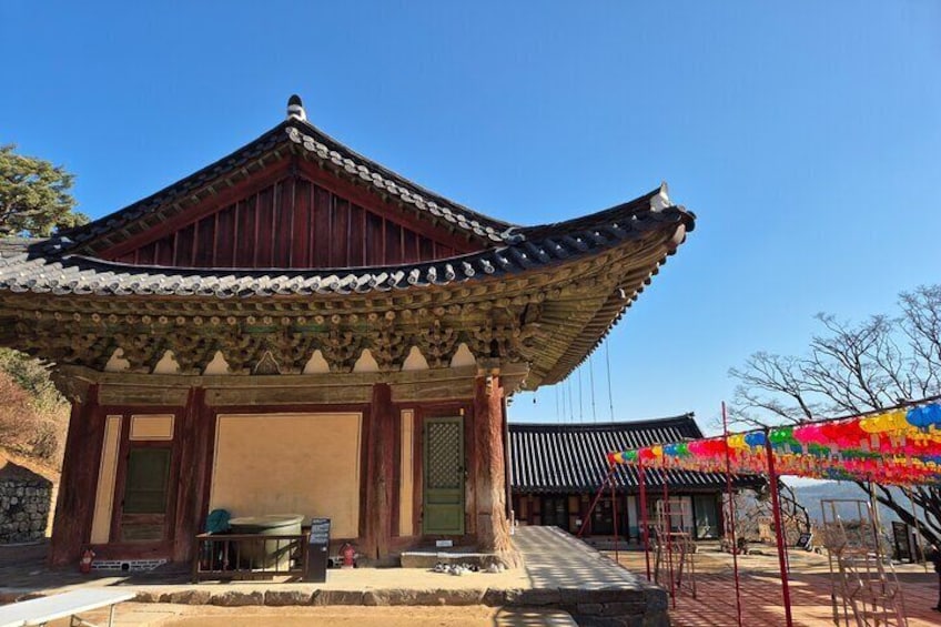 Un edificio coreano tradicional con tejado de tejas y estructura de madera. 2