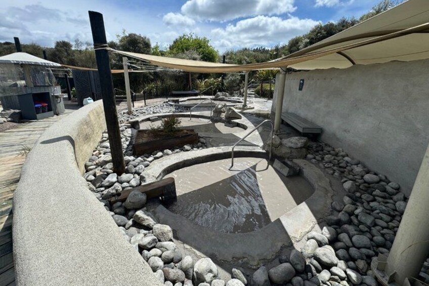 Un área de hidromasaje con terraza de madera, piscina de hormigón y zona sombreada. 2