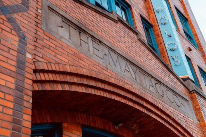 A brick building with the name 'THE MAY TAGO' prominently displayed. 4