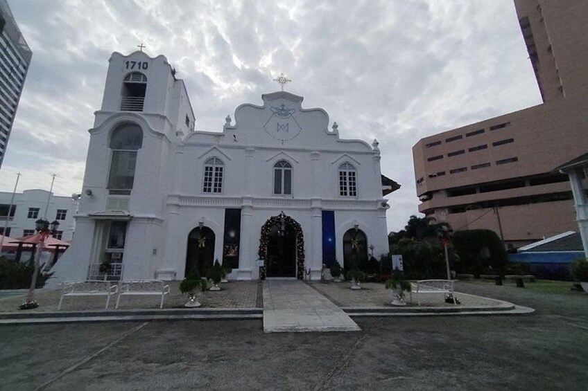 A white church with a bell tower, arched windows, and a central doorway. 3