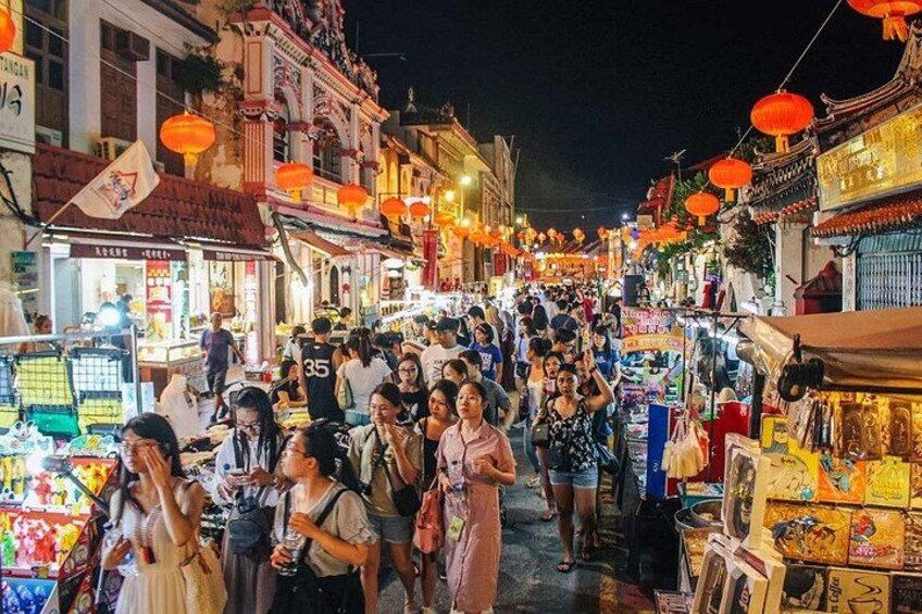 A crowded street market at night with traditional architecture and red lanterns. 2