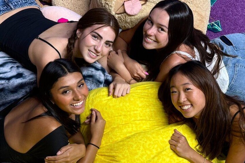 Un grupo de personas descansando sobre una cama con una manta amarilla. 3