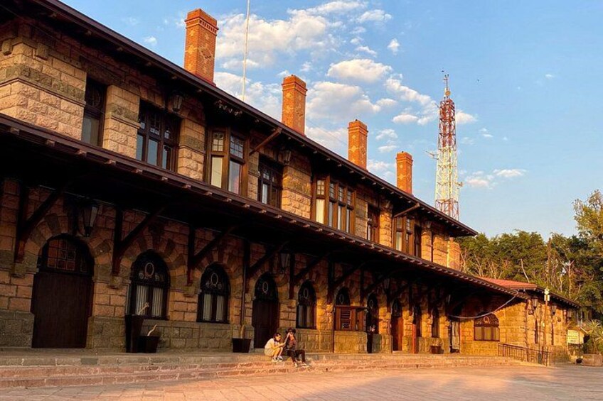A historic train station with arched windows and brick chimneys. 1