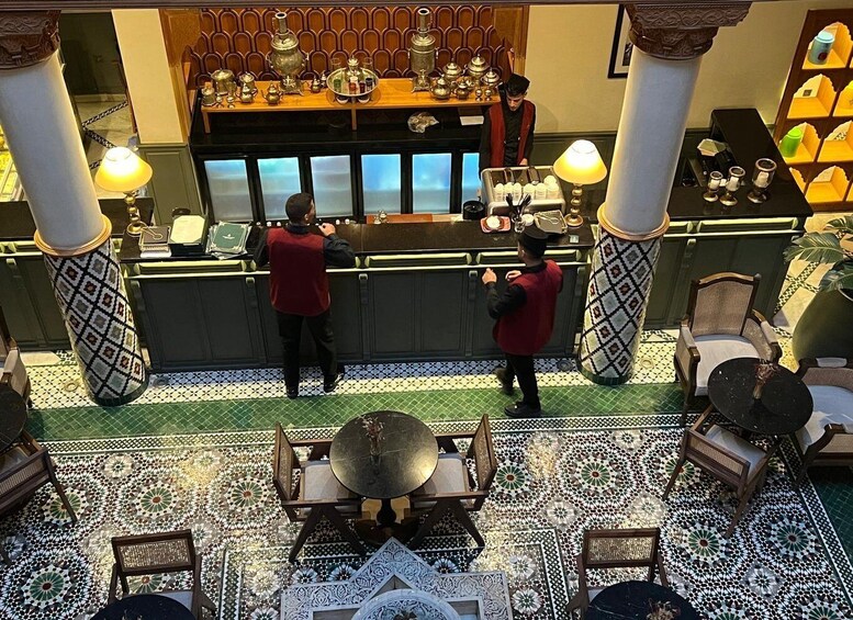 A restaurant interior with a bar area, patterned floor tiles, and a seating area with tables and chairs. 3