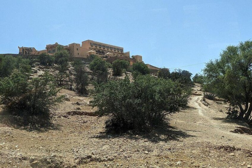 Una ladera con un edificio, vegetación escasa y un sendero de tierra. 4