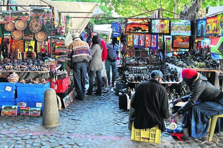 Un marché animé en plein air, avec de nombreux étals vendant toutes sortes de produits. 3