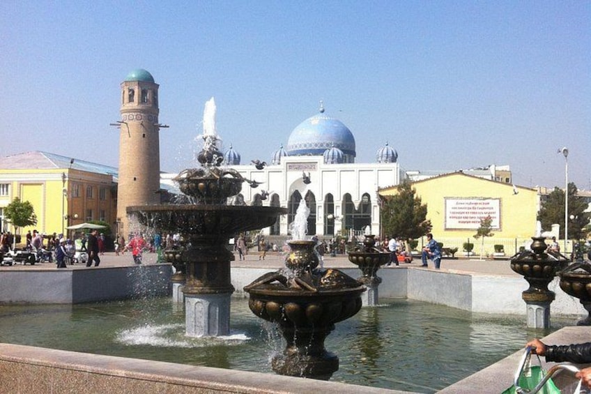 A public square with a fountain, a mosque, and a building with domes. 4