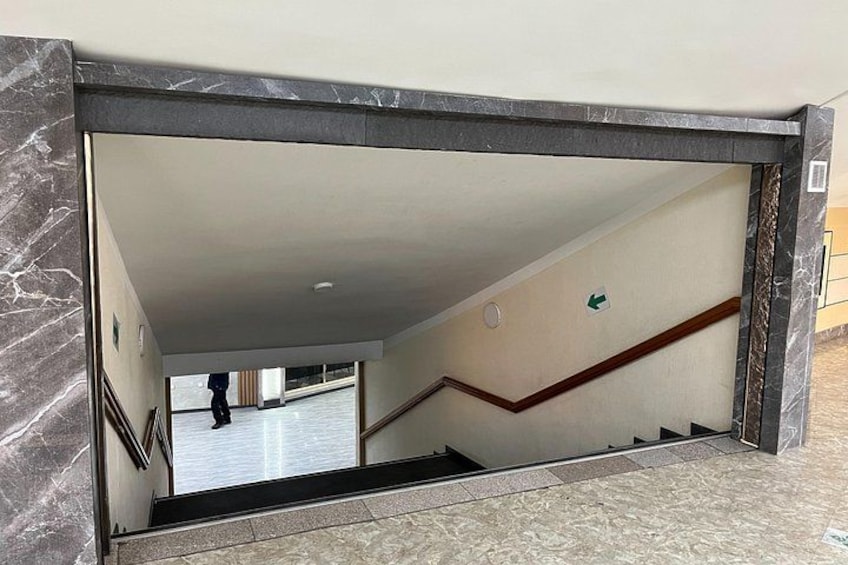 A marble-framed window with a view of a staircase and a person walking. 3