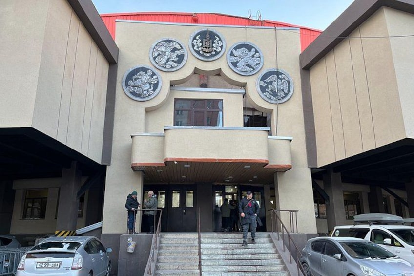 A building with a red roof, multiple circular windows, and a staircase leading to the entrance. 2