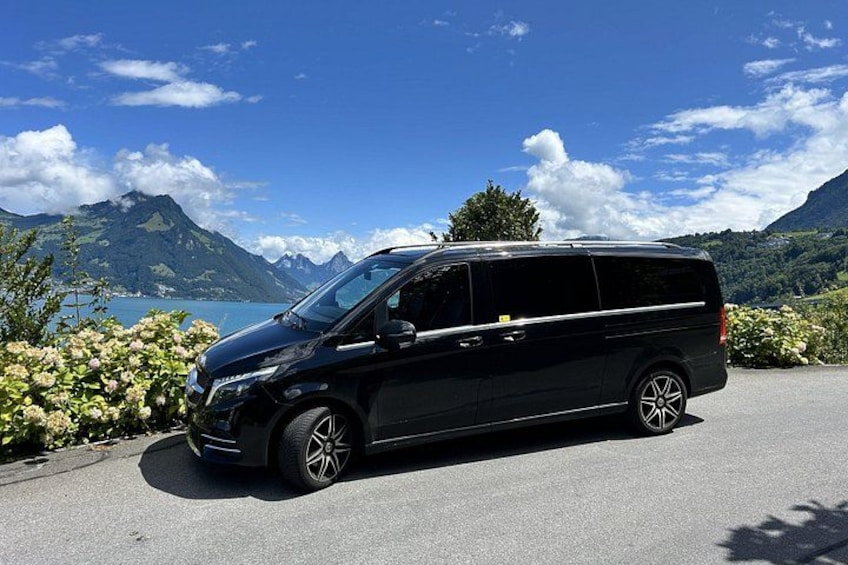 Un minivan nero parcheggiato su una strada con un paesaggio montuoso sullo sfondo. 3