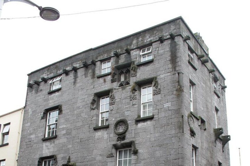 A multi-story building with a stone facade, multiple windows, and decorative elements. 4