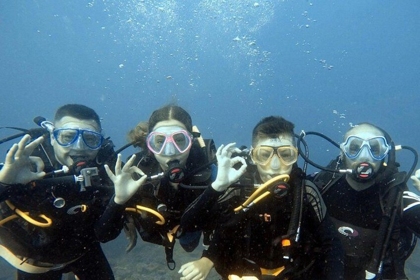 Four scuba divers underwater with their masks and fins. 4