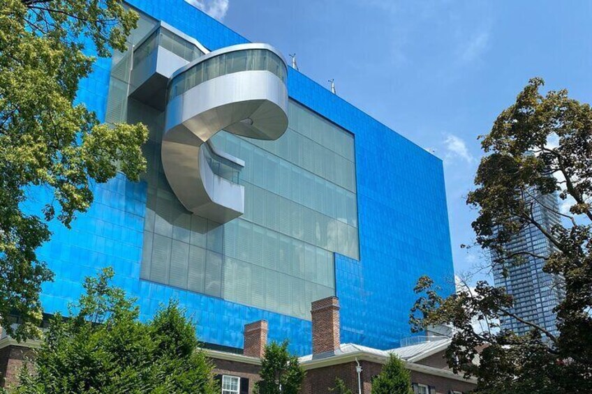 A modern building with a blue facade and a large glass window. 3