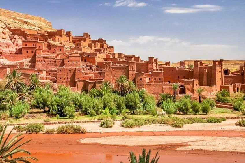 A traditional mud-brick village with terraced structures and palm trees. 3